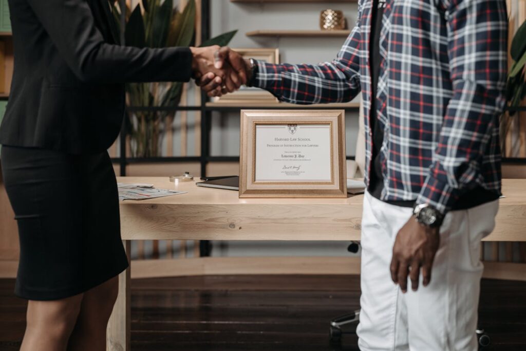 Two professionals sealing a deal with a handshake in a modern office.